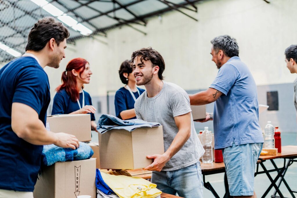 Volunteers packing cardboard boxes at a donation table.