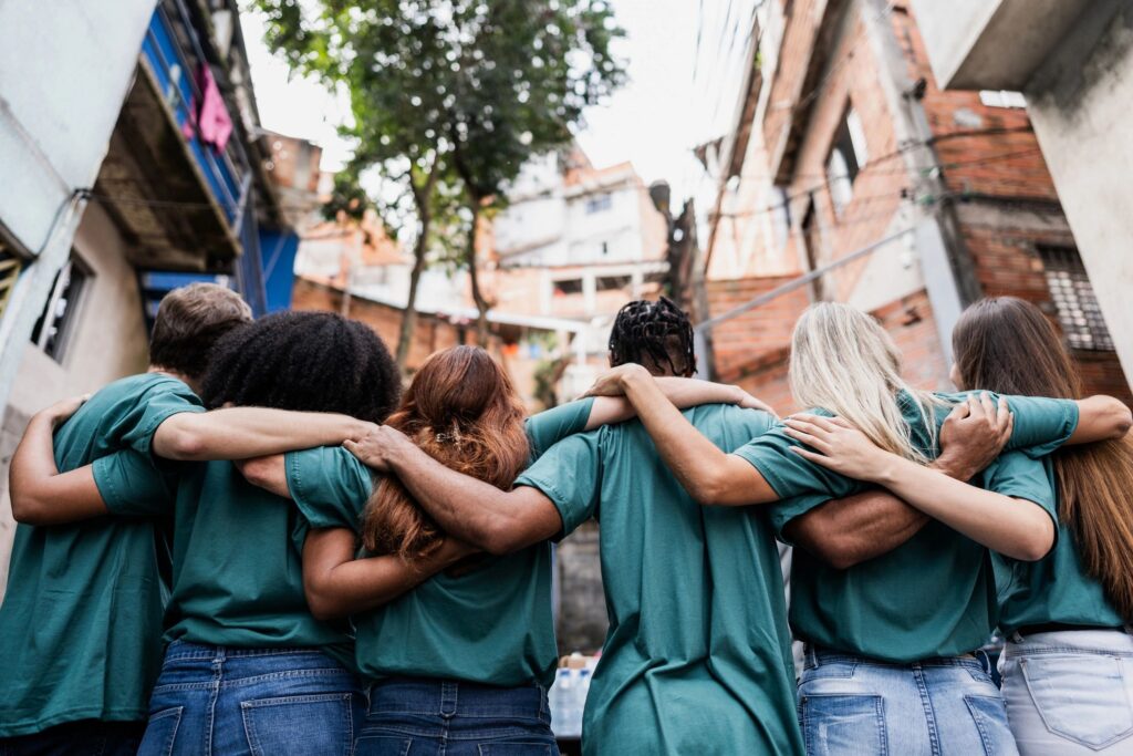 Volunteers standing in a row with their arms around one another.