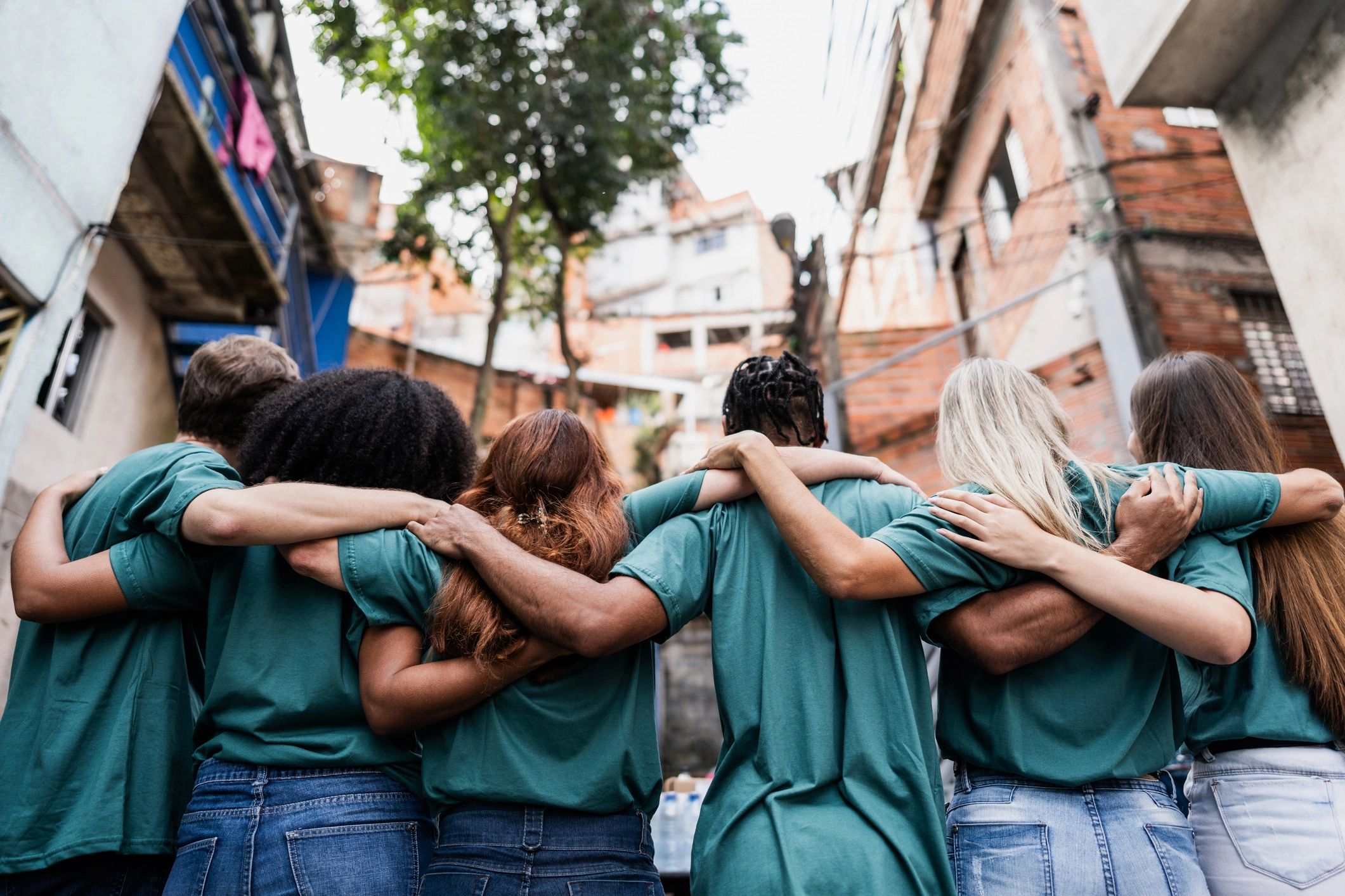 Volunteers standing in a row with their arms around one another.