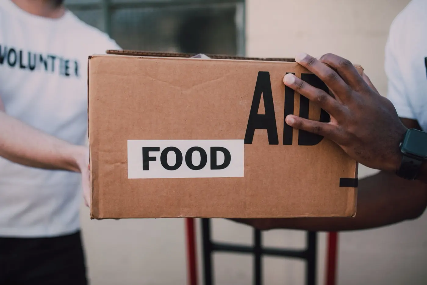 Volunteers carrying a box of food aid.